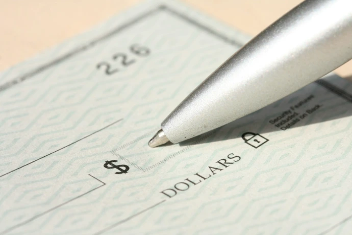 Pen poised over a check, ready to write.